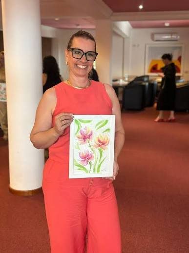 Sandra Weddigen segurando uma aquarela de flores